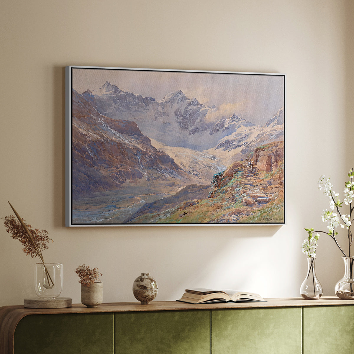 White floater framed canvas of Odenwinklkees with the Johannisberg, 1902 by Edward Theodore Compton, featuring a mountain scene with glacier stretching through rocky valley above a sideboard in a softly lit hallway.