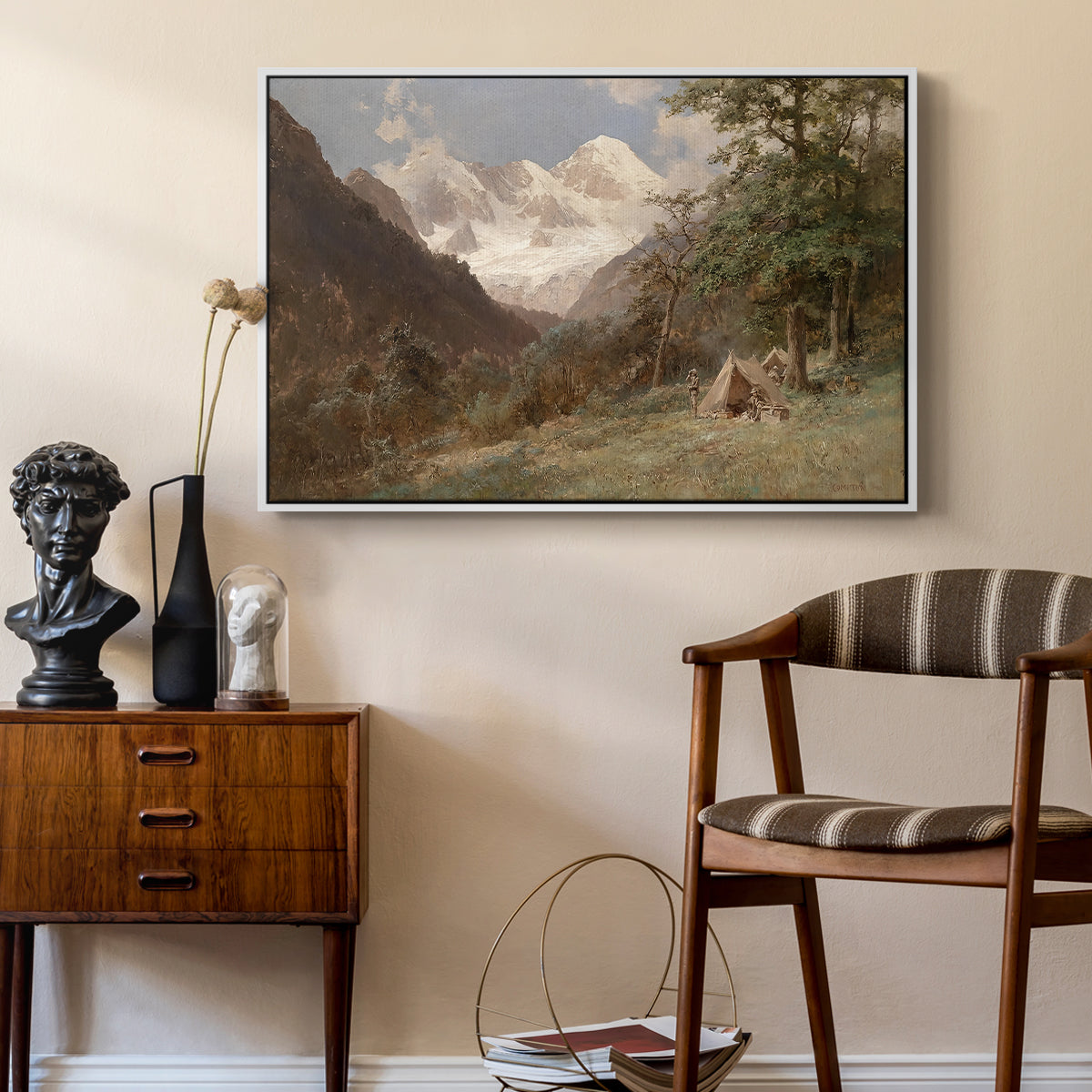 Landscape in the Caucasus, c. 1921 by Edward Theodore Compton as a white floater framed canvas featuring a natural scene with valleys and rocky formations, styled above a mid-century console in a contemporary living area.