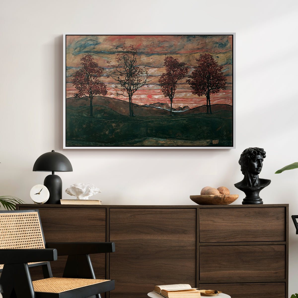 Four Trees, 1917 by Egon Schiele displayed in a white floater framed canvas above a dark wood credenza in an entryway.