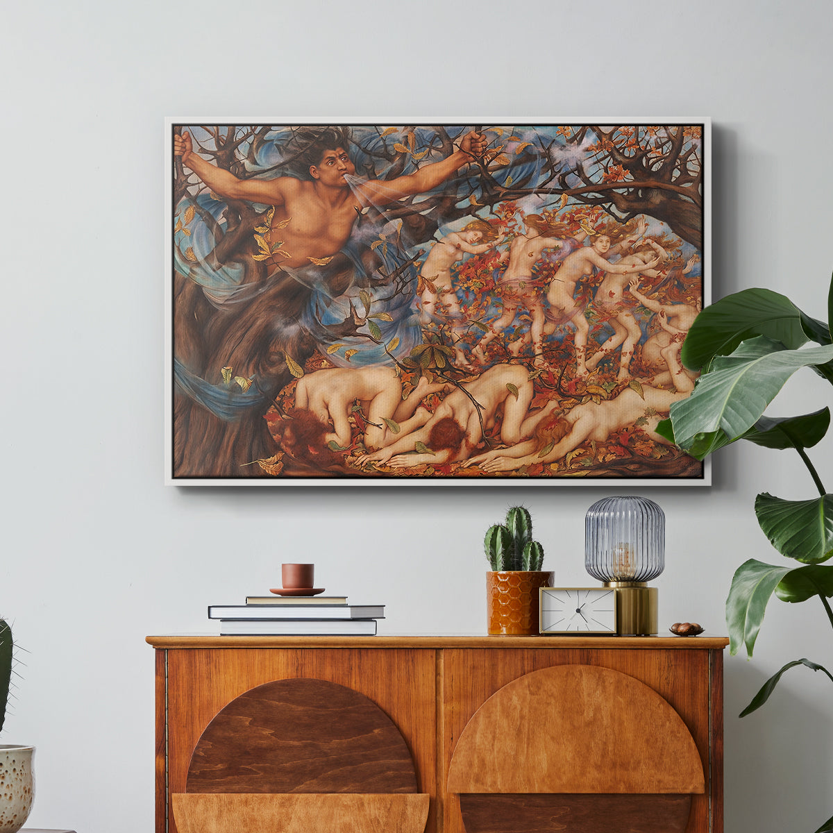 Boreas and the Fallen Leaves, c. 1910-1914 by Evelyn De Morgan in a white floater framed canvas featuring swirling figures carried by wind among falling leaves in dynamic composition, displayed above a wood console cabinet.