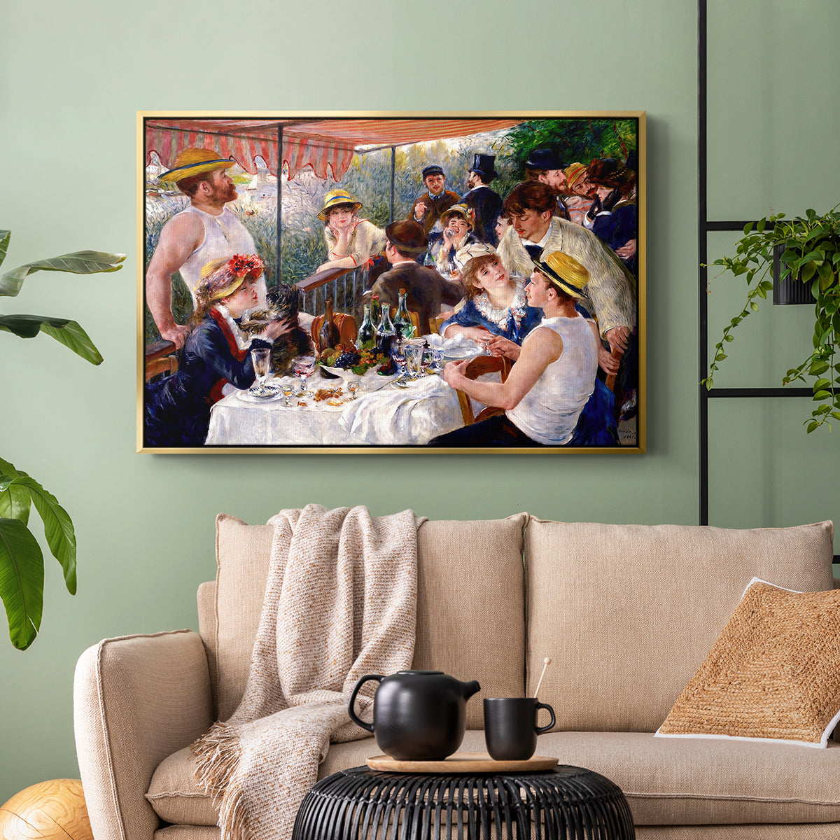 Gold floater framed canvas featuring a social dining scene with figures seated around table on riverside terrace, displayed above a sofa in a modern living room.