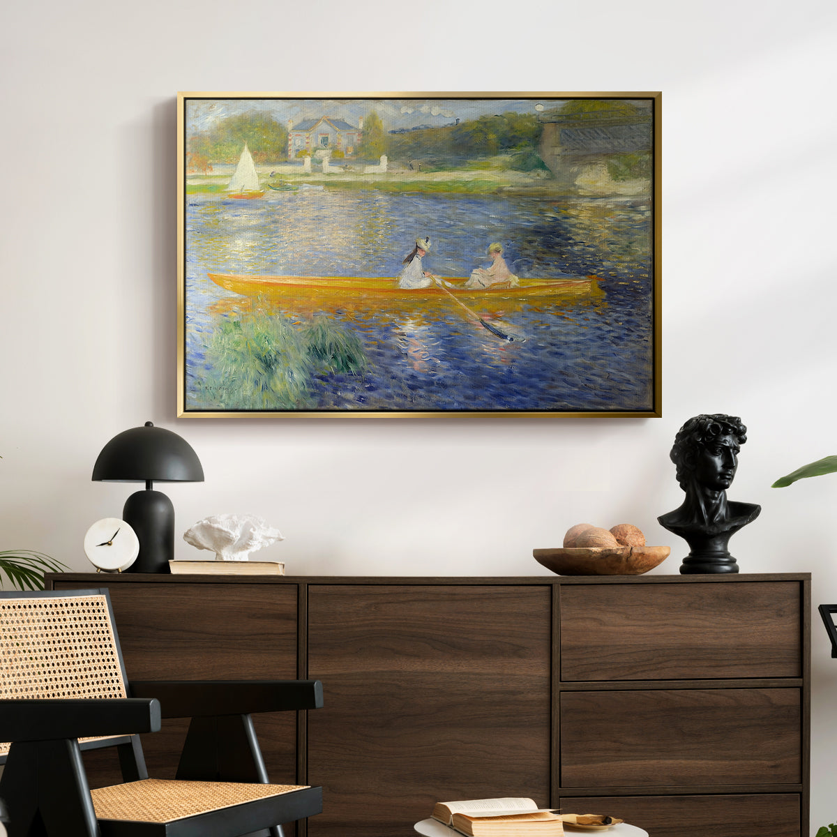 The Skiff (La Yole), 1875 by Pierre-Auguste Renoir displayed in a gold floater framed canvas above a dark wood credenza in an entryway.