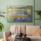 Gold floater framed canvas featuring a leisure scene of figures in a small rowboat on tranquil water, displayed above a sofa in a modern living room.