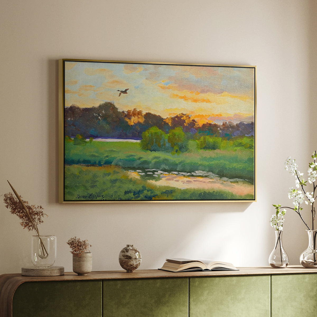 Gold floater framed canvas of Flying Duck at Sunset, 1924 by Bruno Liljefors, featuring a lone duck soaring over a glowing marshland above a sideboard in a softly lit hallway.