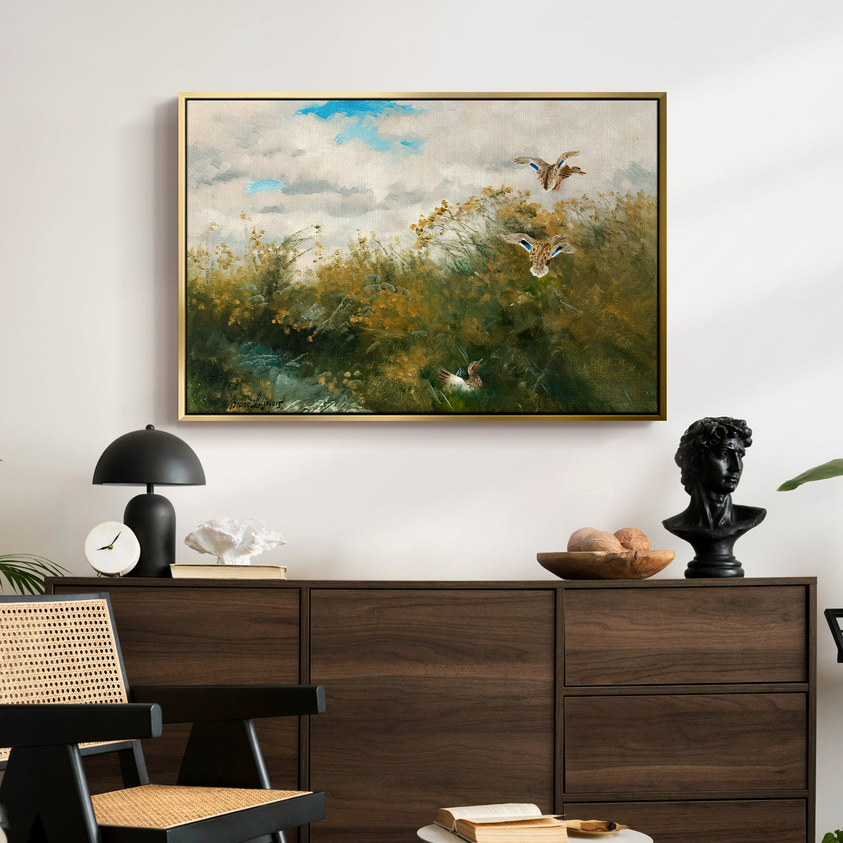 Wild Ducks (Grasänder), 1890 by Bruno Liljefors displayed in a gold floater framed canvas above a dark wood credenza in an entryway.
