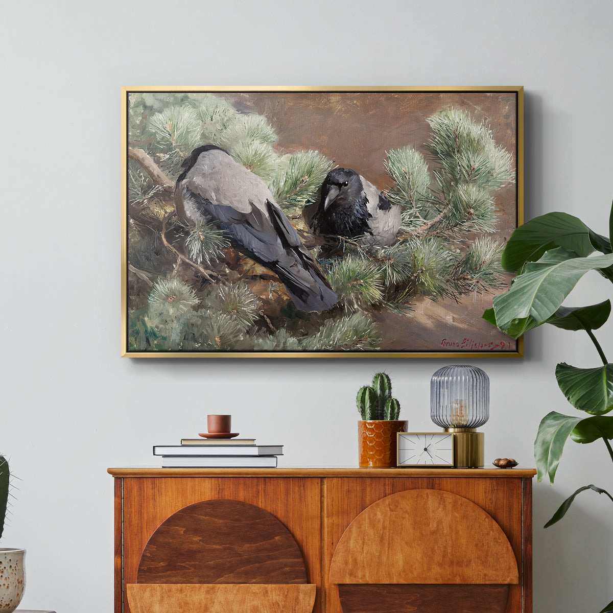 Hooded Crows (Kråkor), 1891 by Bruno Liljefors in a gold floater framed canvas featuring two crows perched on ground among grass and earth tones, displayed above a wood console cabinet.