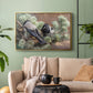 Gold floater framed canvas featuring a wildlife painting of dark birds against muted landscape, displayed above a sofa in a modern living room.