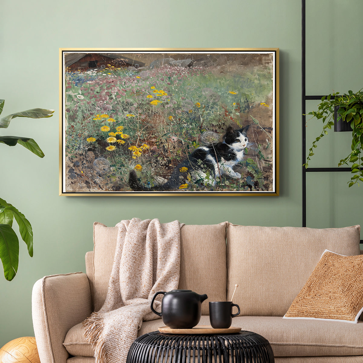Gold floater framed canvas featuring a naturalistic depiction of cat in blooming countryside setting, displayed above a sofa in a modern living room.