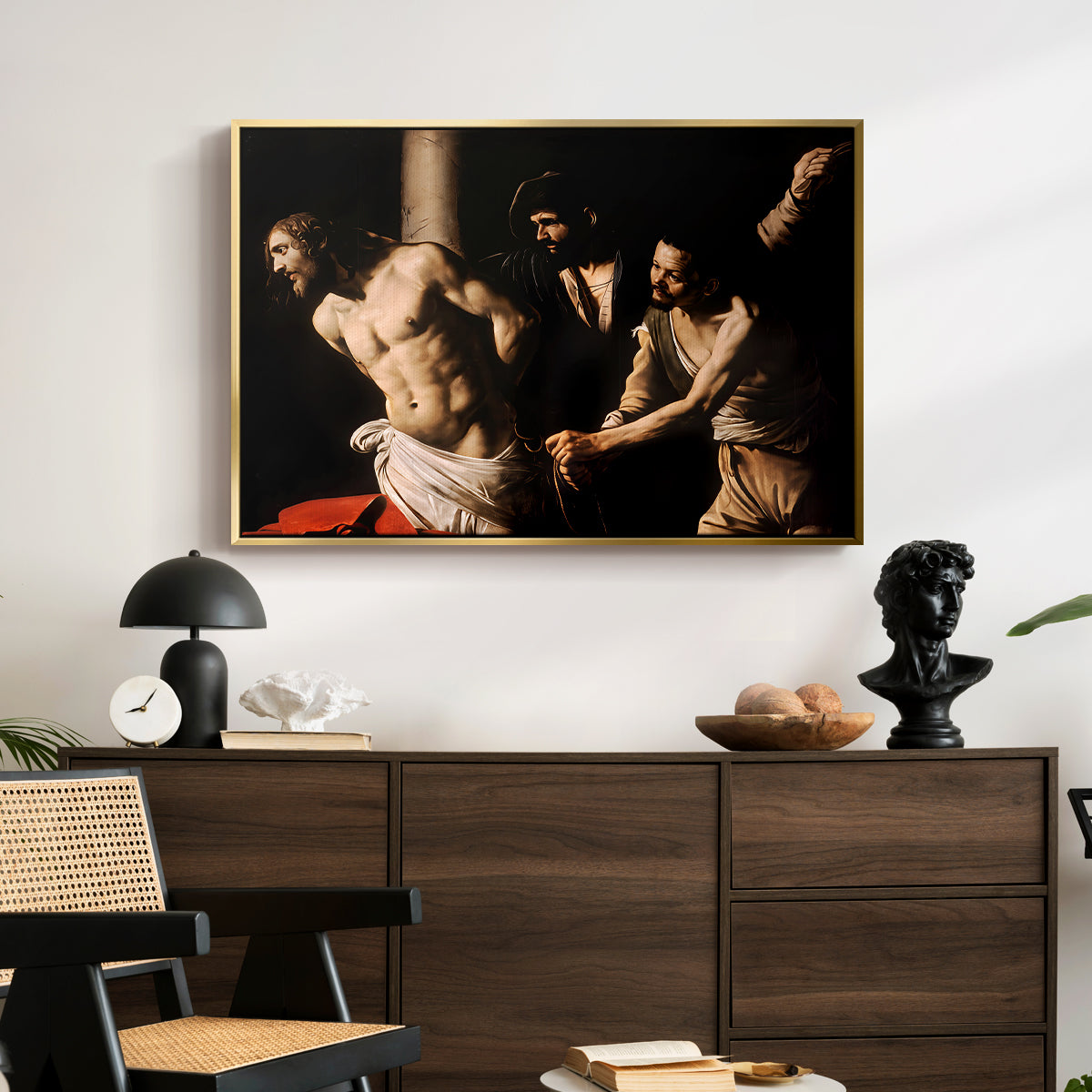The Flagellation of Christ at the Column (Rouen Version), 1606 by Caravaggio displayed in a gold floater framed canvas above a dark wood credenza in an entryway.