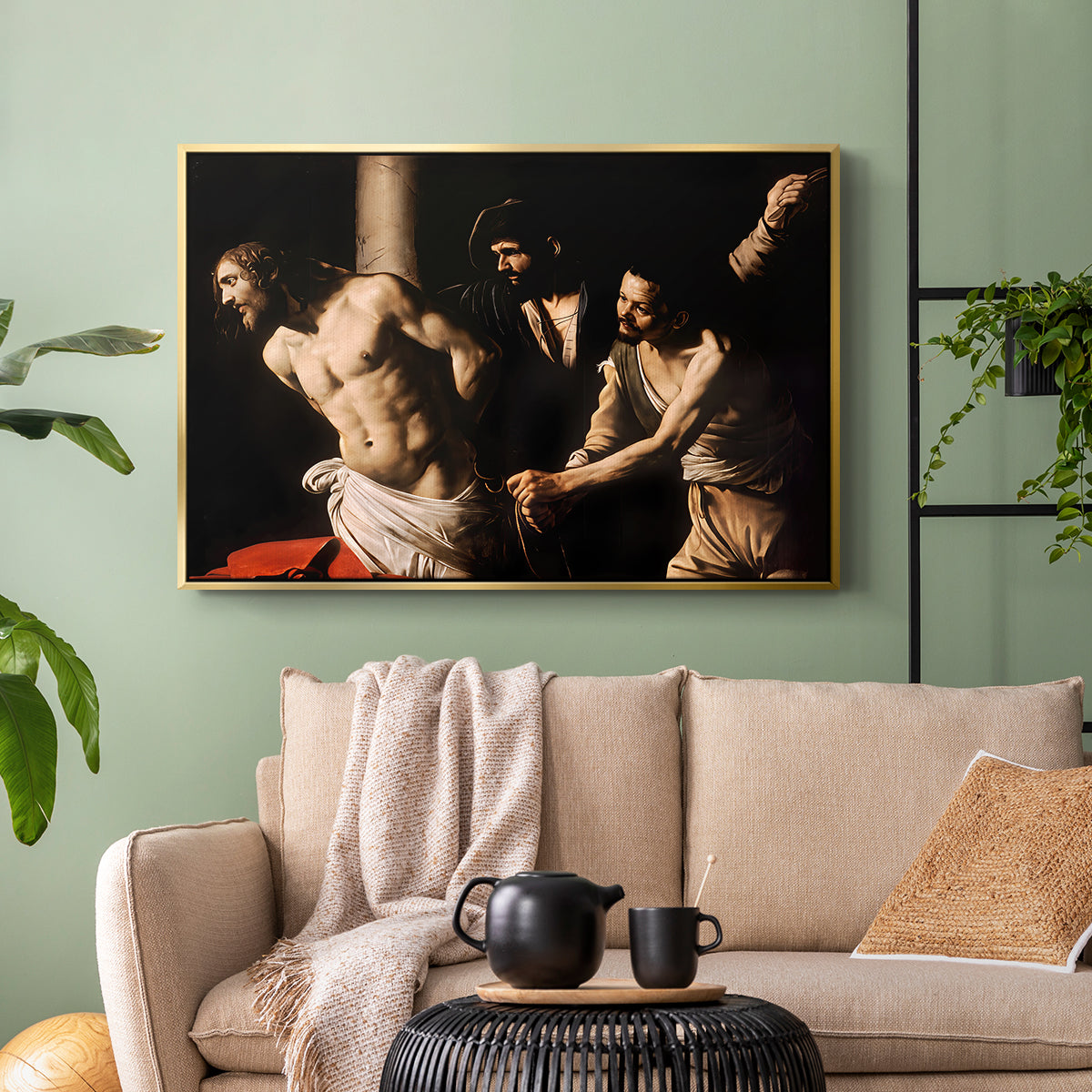 Gold floater framed canvas featuring an intense Baroque scene of suffering with strong light and shadow, displayed above a sofa in a modern living room.