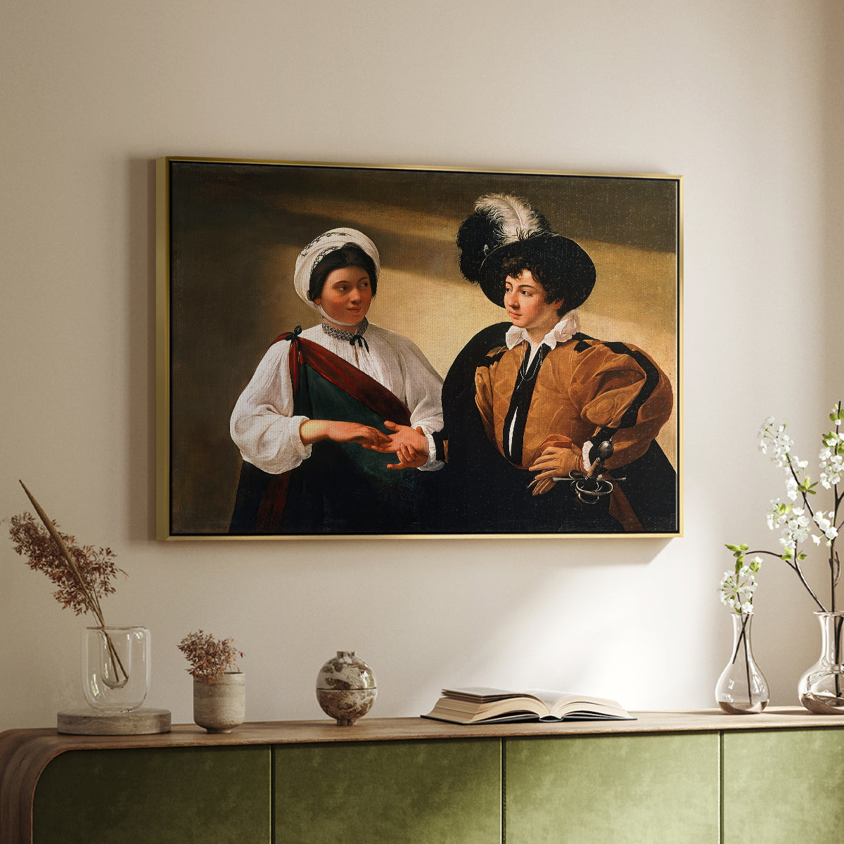Gold floater framed canvas of The Fortune Teller (Louvre Version), c. 1595 by Caravaggio, featuring a fortune teller examining hand of man as she slyly removes his ring above a sideboard in a softly lit hallway.