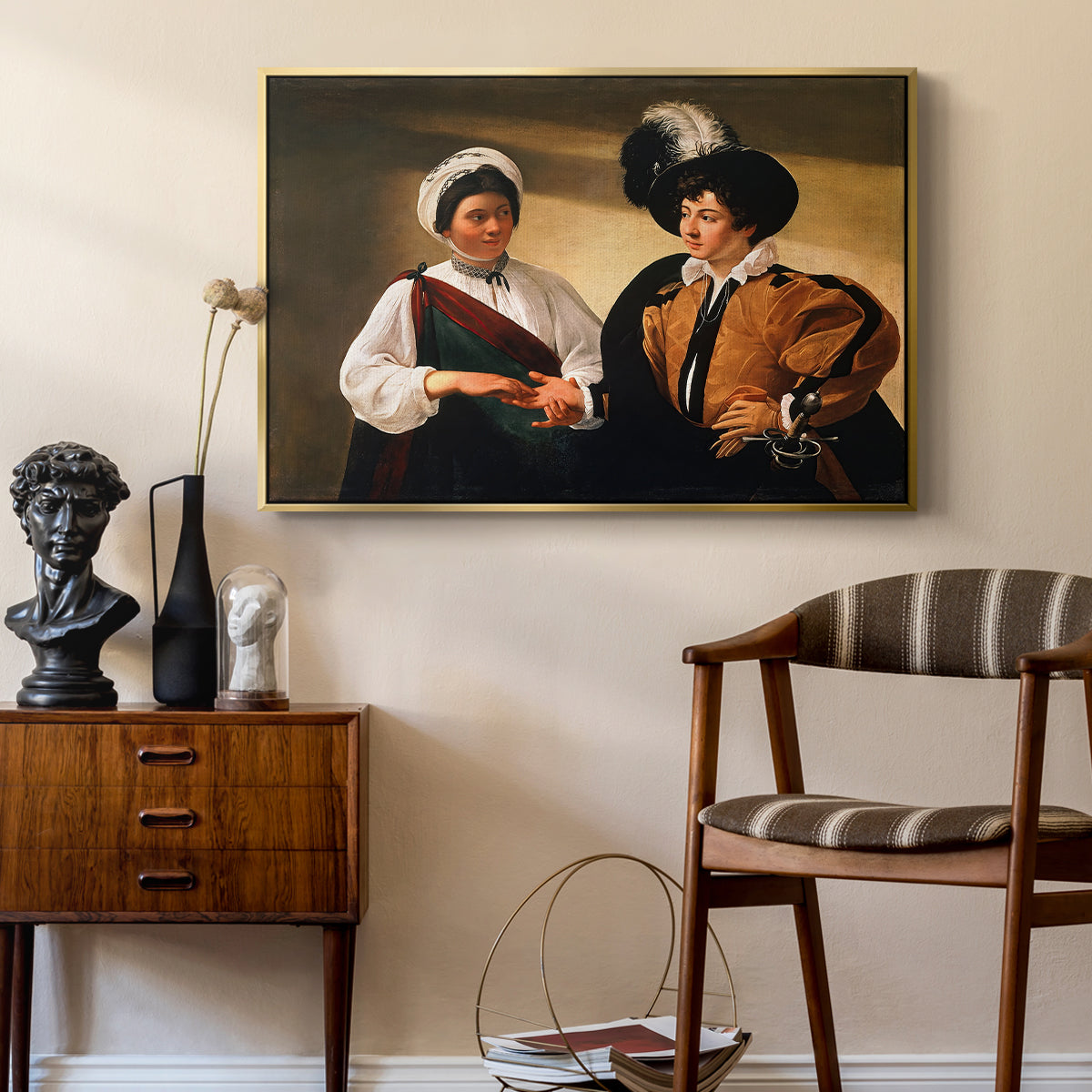 The Fortune Teller (Louvre Version), c. 1595 by Caravaggio as a gold floater framed canvas featuring an intimate scene of palm reading with subtle act of theft, styled above a mid-century console in a contemporary living area.