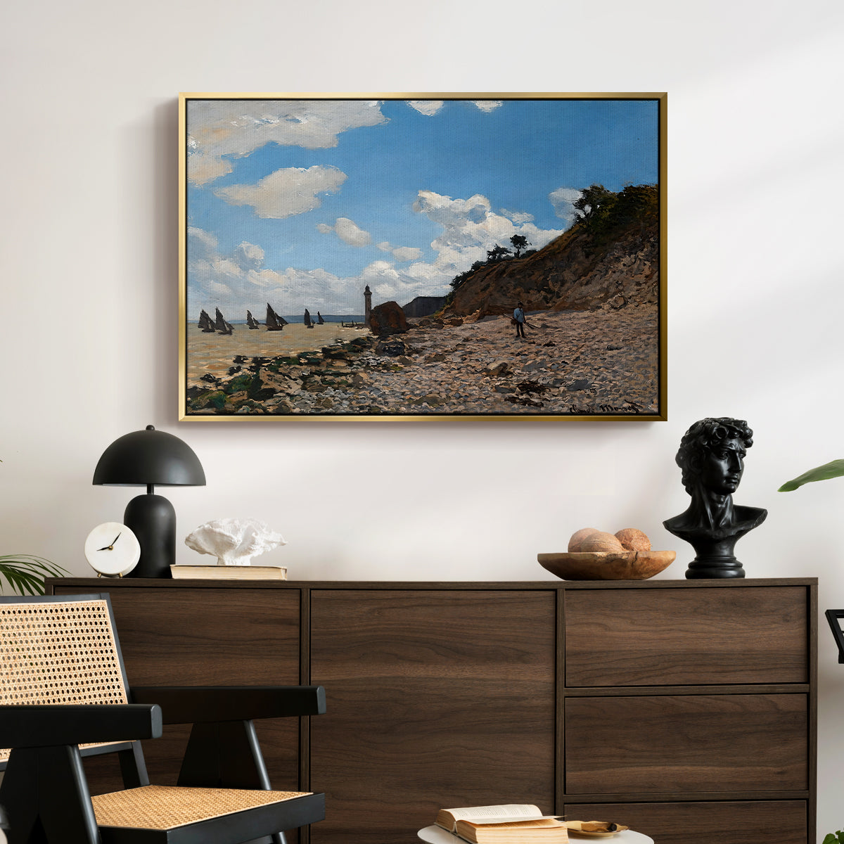 The Beach at Honfleur, 1864 by Claude Monet displayed in a gold floater framed canvas above a dark wood credenza in an entryway.