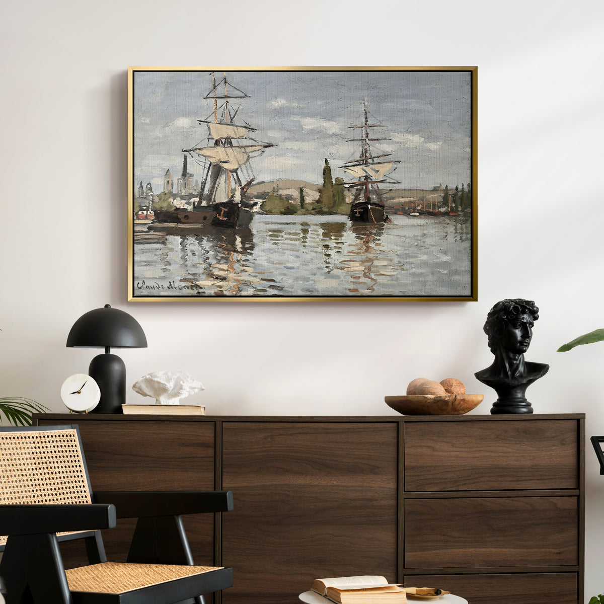 Ships Riding on the Seine at Rouen, 1872 by Claude Monet displayed in a gold floater framed canvas above a dark wood credenza in an entryway.