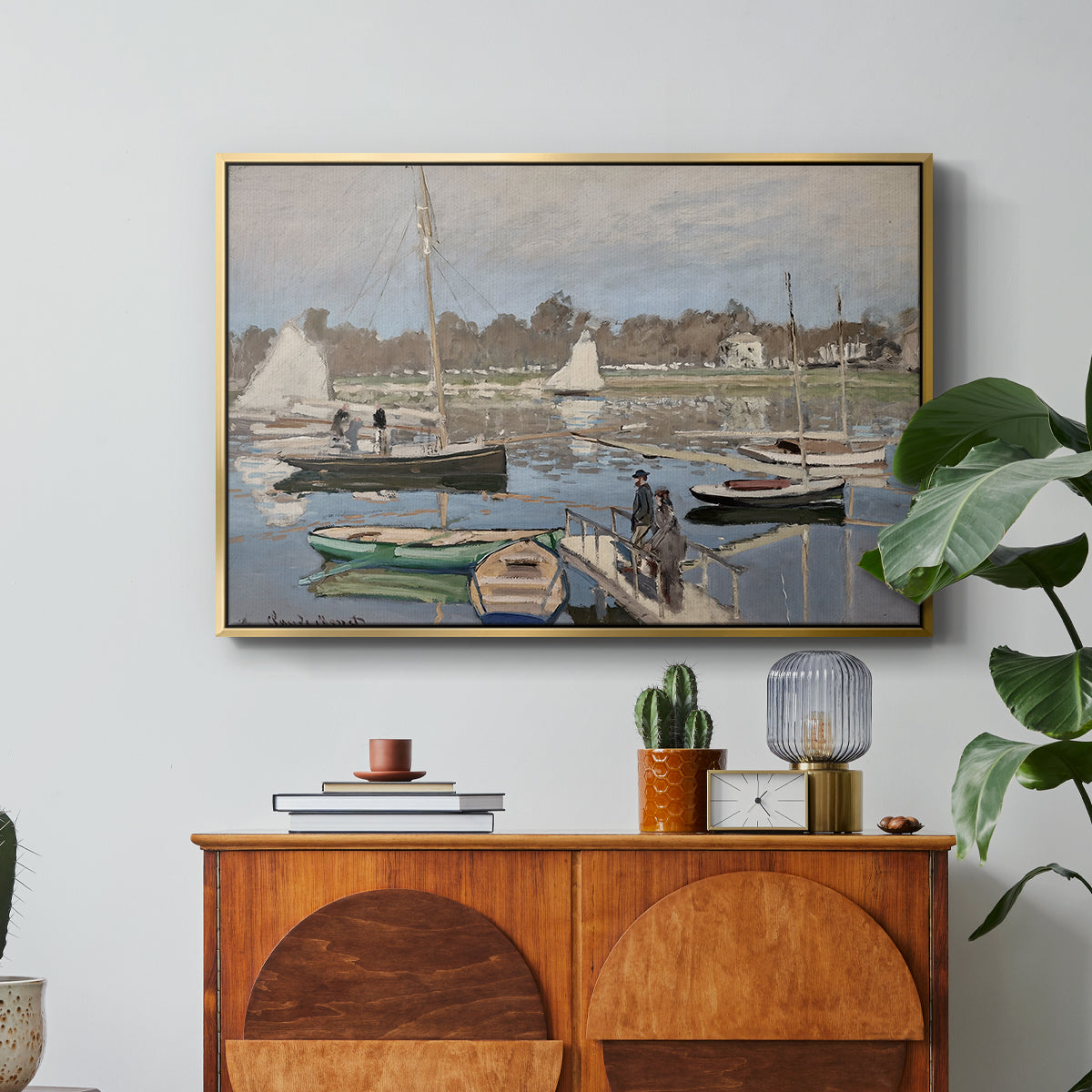 The Basin at Argenteuil, 1874 by Claude Monet in a gold floater framed canvas featuring sailboats gathered in calm basin with reflections on water, displayed above a wood console cabinet.