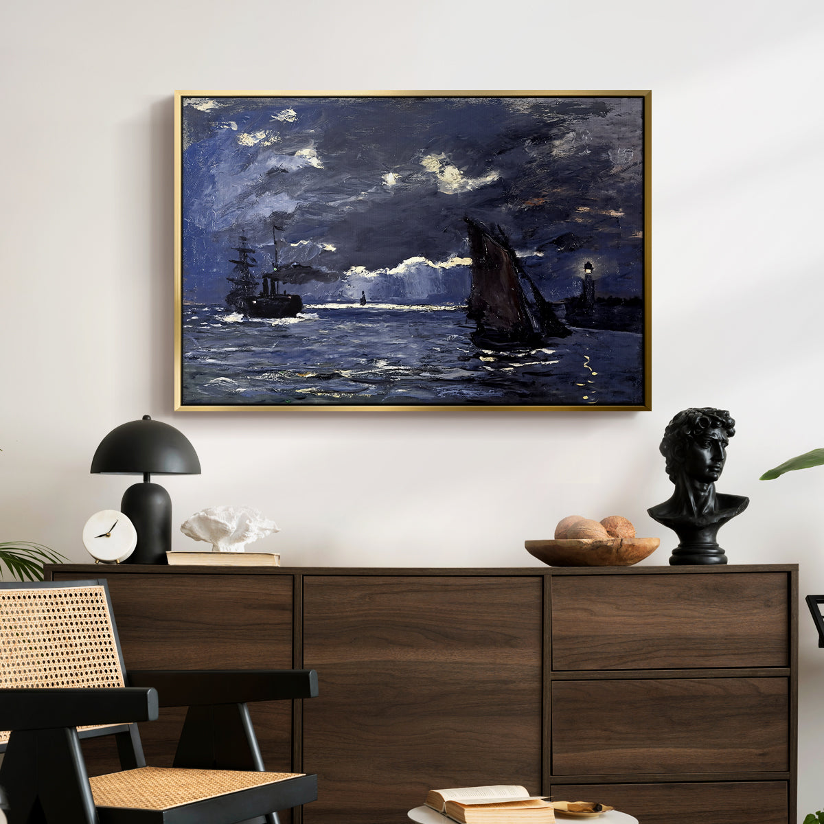 A Seascape, Shipping by Moonlight, 1864 by Claude Monet displayed in a gold floater framed canvas above a dark wood credenza in an entryway.