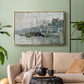 Gold floater framed canvas featuring a harbor view with masts, houses, and reflections in water, displayed above a sofa in a modern living room.