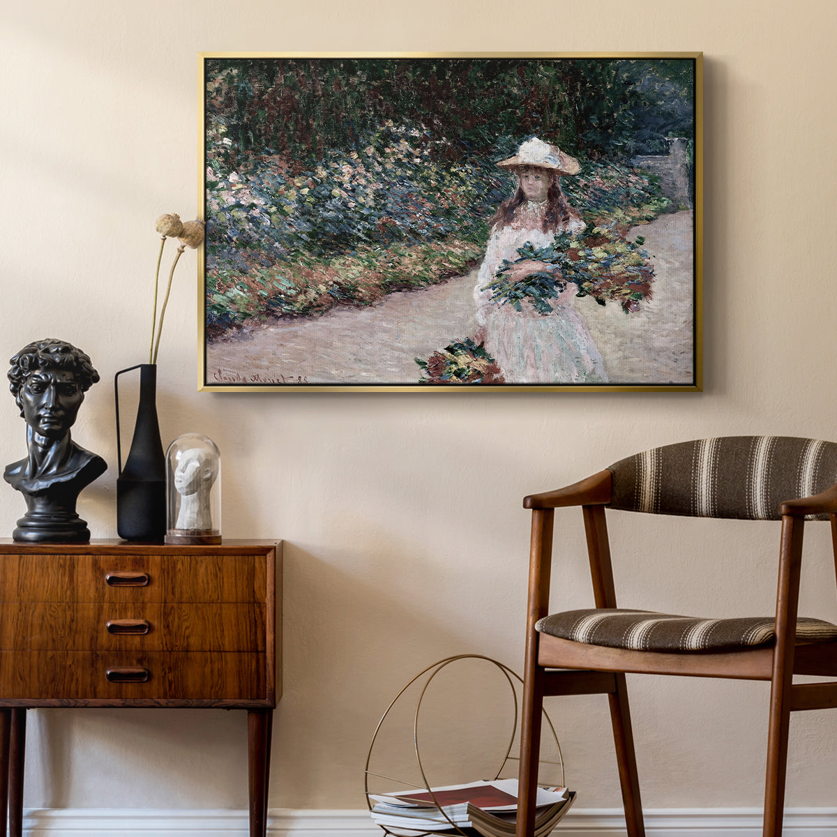 Young Girl in the Garden at Giverny, 1888 by Claude Monet as a gold floater framed canvas featuring a figure resting in colorful garden under soft light, styled above a mid-century console in a contemporary living area.