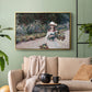 Gold floater framed canvas featuring a tranquil outdoor portrait of girl in floral setting, displayed above a sofa in a modern living room.