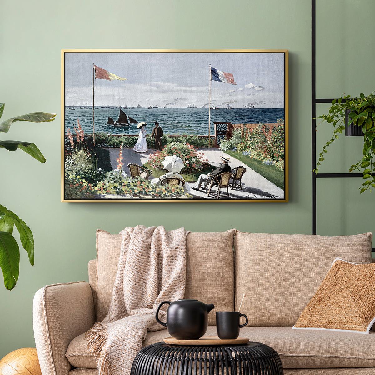 Gold floater framed canvas featuring a landscaped terrace with figures and flags near shoreline, displayed above a sofa in a modern living room.