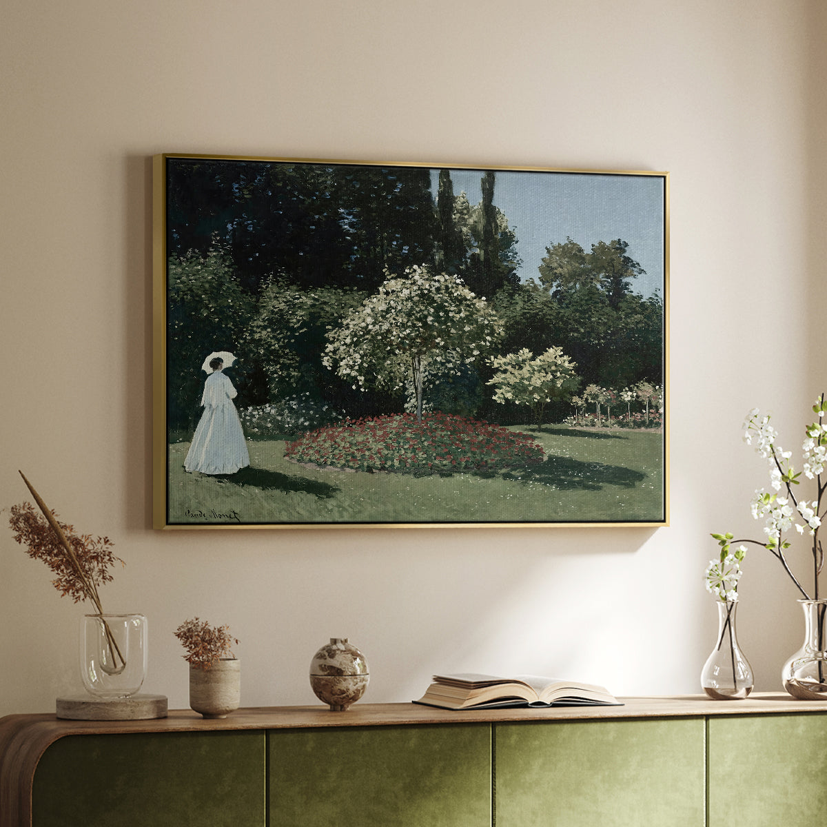 Gold floater framed canvas of Woman in the Garden, Sainte-Adresse, 1867 by Claude Monet, featuring an impressionist figure in sunlit garden with lush vegetation above a sideboard in a softly lit hallway.