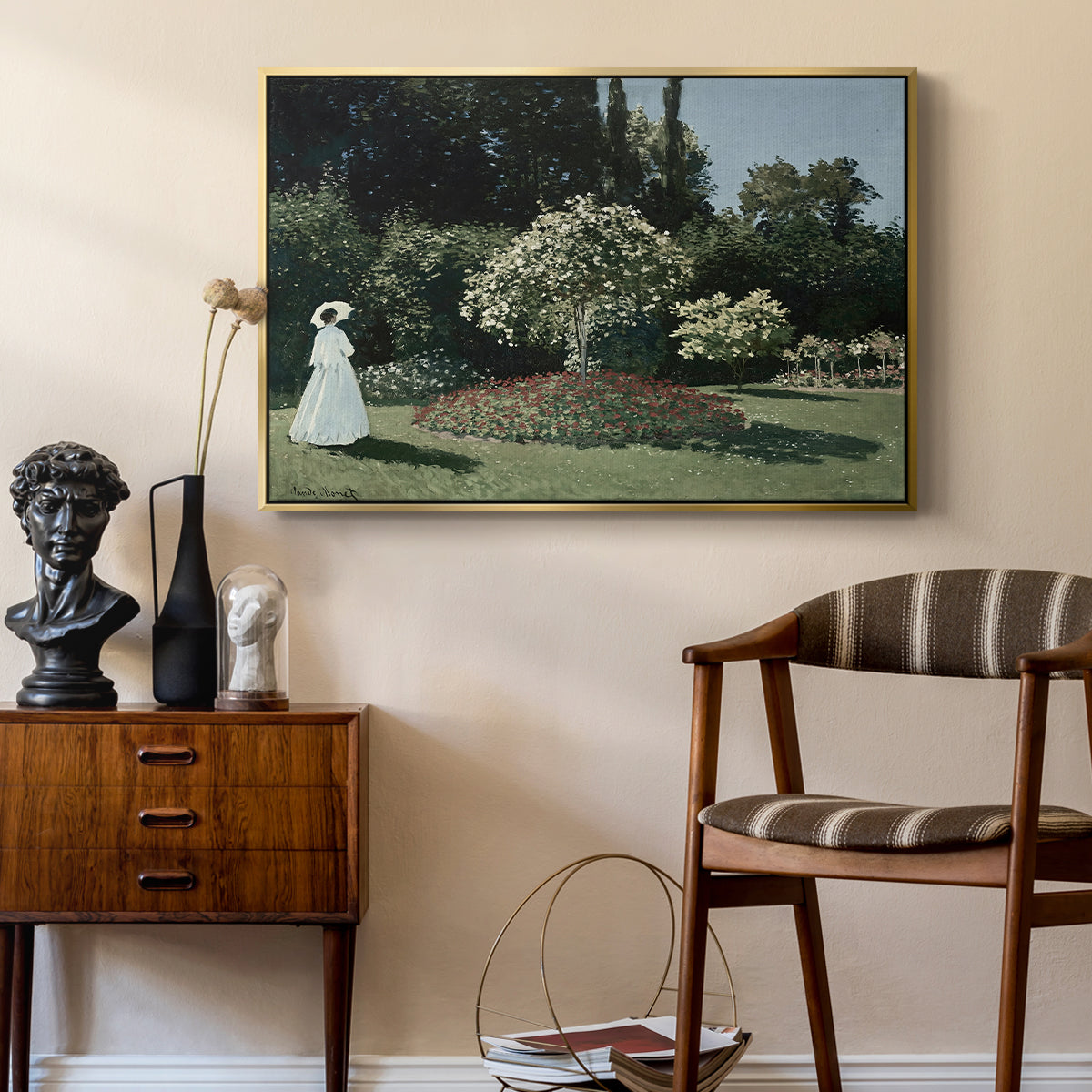 Woman in the Garden, Sainte-Adresse, 1867 by Claude Monet as a gold floater framed canvas featuring an elegant woman posed outdoors among blooming plants, styled above a mid-century console in a contemporary living area.