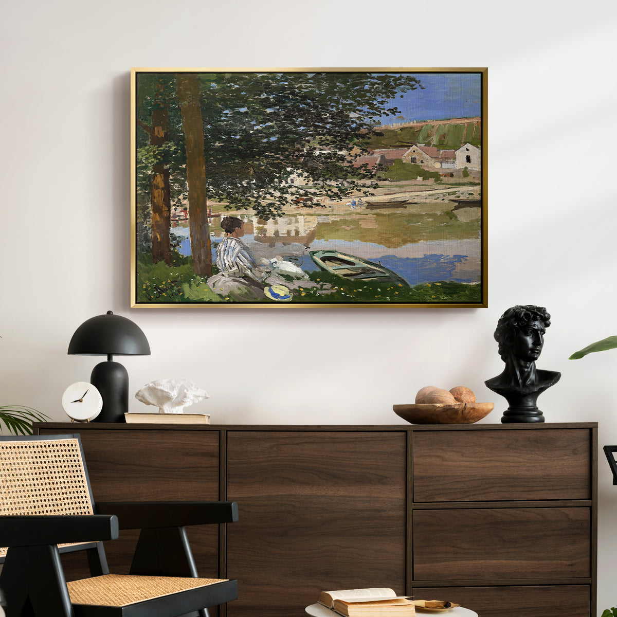 On the Bank of the Seine, Bennecourt, 1868 by Claude Monet displayed in a gold floater framed canvas above a dark wood credenza in an entryway.