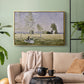 Gold floater framed canvas featuring a tranquil summer landscape with lone figure in nature, displayed above a sofa in a modern living room.