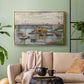 Gold floater framed canvas featuring a subdued urban landscape with structure spanning river, displayed above a sofa in a modern living room.
