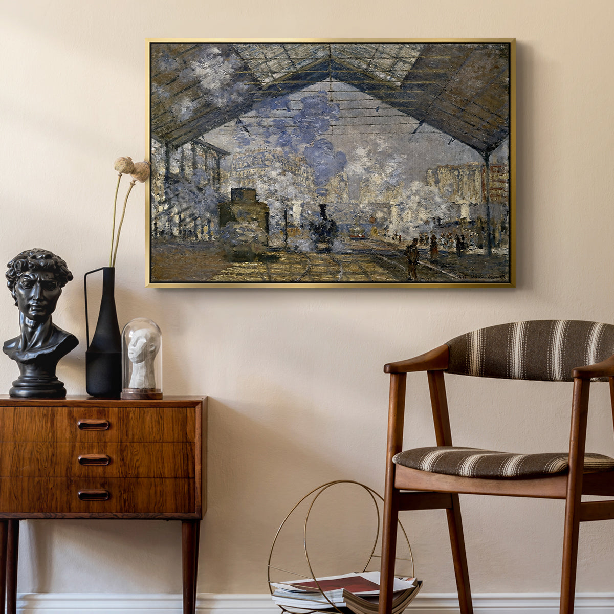 The Gare Saint-Lazare, 1877 by Claude Monet as a gold floater framed canvas featuring an industrial interior with steam clouds and rail tracks, styled above a mid-century console in a contemporary living area.