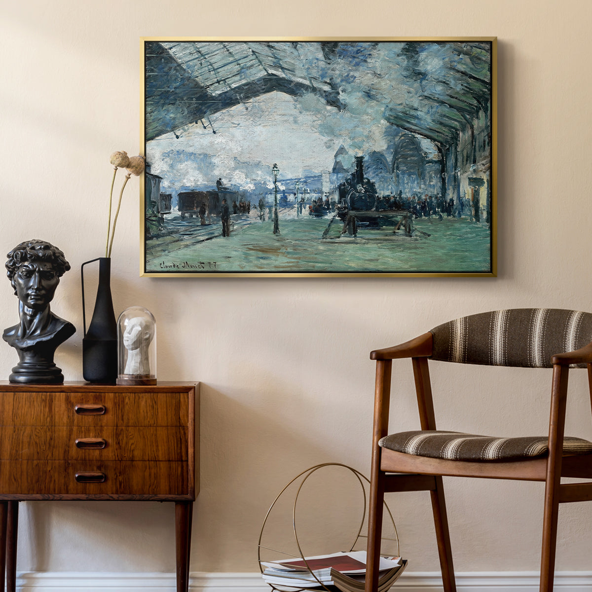 The Saint-Lazare Station, 1877 by Claude Monet as a gold floater framed canvas featuring an interior view of station filled with movement and smoke, styled above a mid-century console in a contemporary living area.