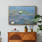 Water Lilies (Nymphéas), 1897-1899 by Claude Monet in a gold floater framed canvas featuring floating water lilies on pond with reflections of sky and foliage, displayed above a wood console cabinet.