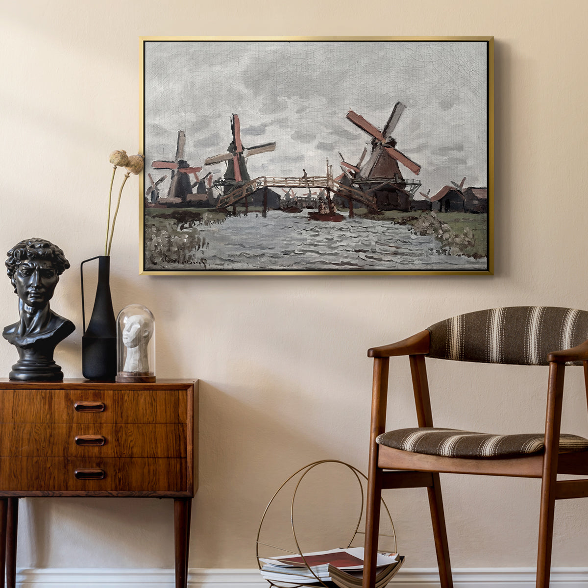 Windmills near Zaandam, 1871 by Claude Monet as a gold floater framed canvas featuring a countryside scene with traditional windmills and reflections, styled above a mid-century console in a contemporary living area.