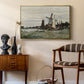 Windmill at Zaandam, 1871 by Claude Monet as a gold floater framed canvas featuring a rustic scene with windmill and reflections in water, styled above a mid-century console in a contemporary living area.