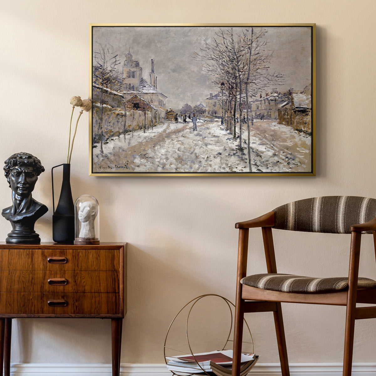 The Boulevard de Pontoise at Argenteuil, Snow Effect, 1875 by Claude Monet as a gold floater framed canvas featuring a quiet boulevard blanketed in snow with distant figures, styled above a mid-century console in a contemporary living area.