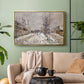 Gold floater framed canvas featuring an urban winter landscape with muted tones and soft light, displayed above a sofa in a modern living room.