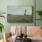 Gold floater framed canvas featuring a natural field scene with vibrant red flowers, displayed above a sofa in a modern living room.