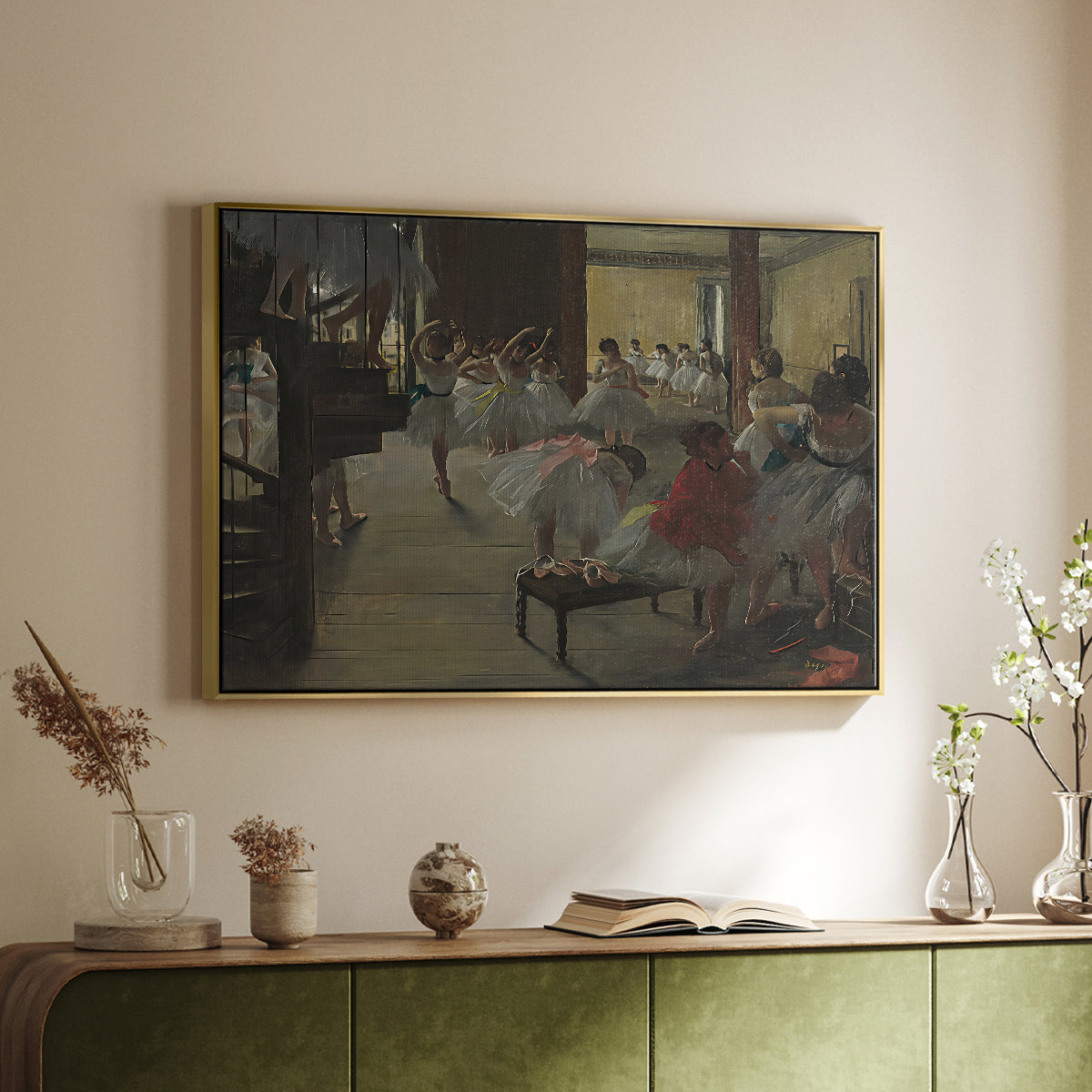 Gold floater framed canvas of The Dance Class, c. 1873 by Edgar Degas, featuring a rehearsal scene with dancers stretching and posing indoors above a sideboard in a softly lit hallway.