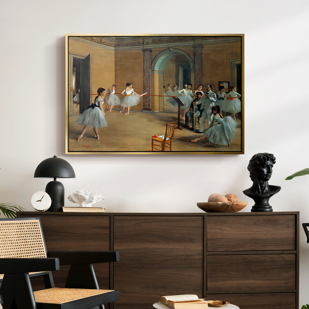 The Dance Foyer at the Opera on the Rue Le Peletier, 1872 by Edgar Degas displayed in a gold floater framed canvas above a dark wood credenza in an entryway.