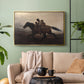 Gold floater framed canvas featuring figures on horse moving swiftly through shadowy landscape, displayed above a sofa in a modern living room.