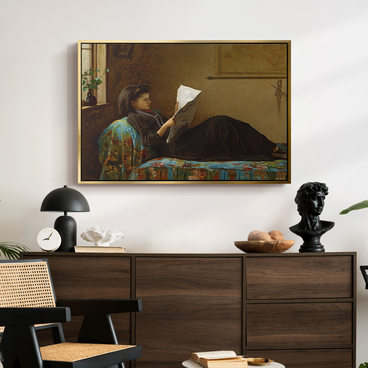 Interesting News, 1872 by Eastman Johnson displayed in a gold floater framed canvas above a dark wood credenza in an entryway.