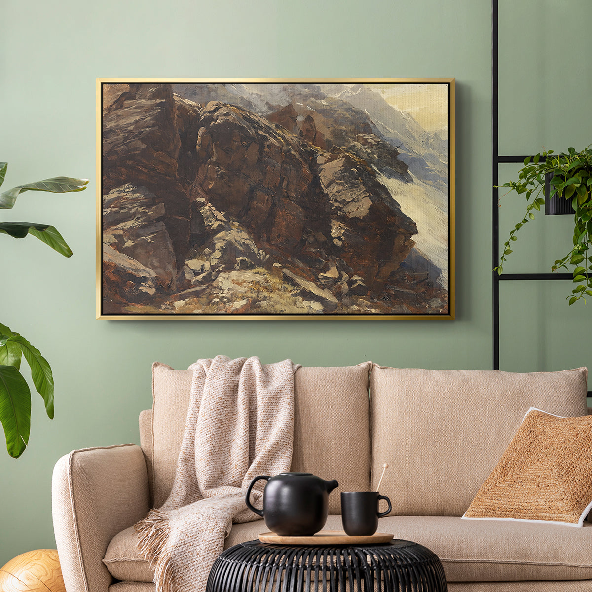 Gold floater framed canvas featuring a realistic depiction of mountainous terrain under open sky, displayed above a sofa in a modern living room.