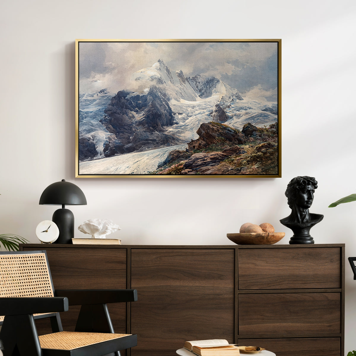 The Grossglockner, 1880 by Edward Theodore Compton displayed in a gold floater framed canvas above a dark wood credenza in an entryway.