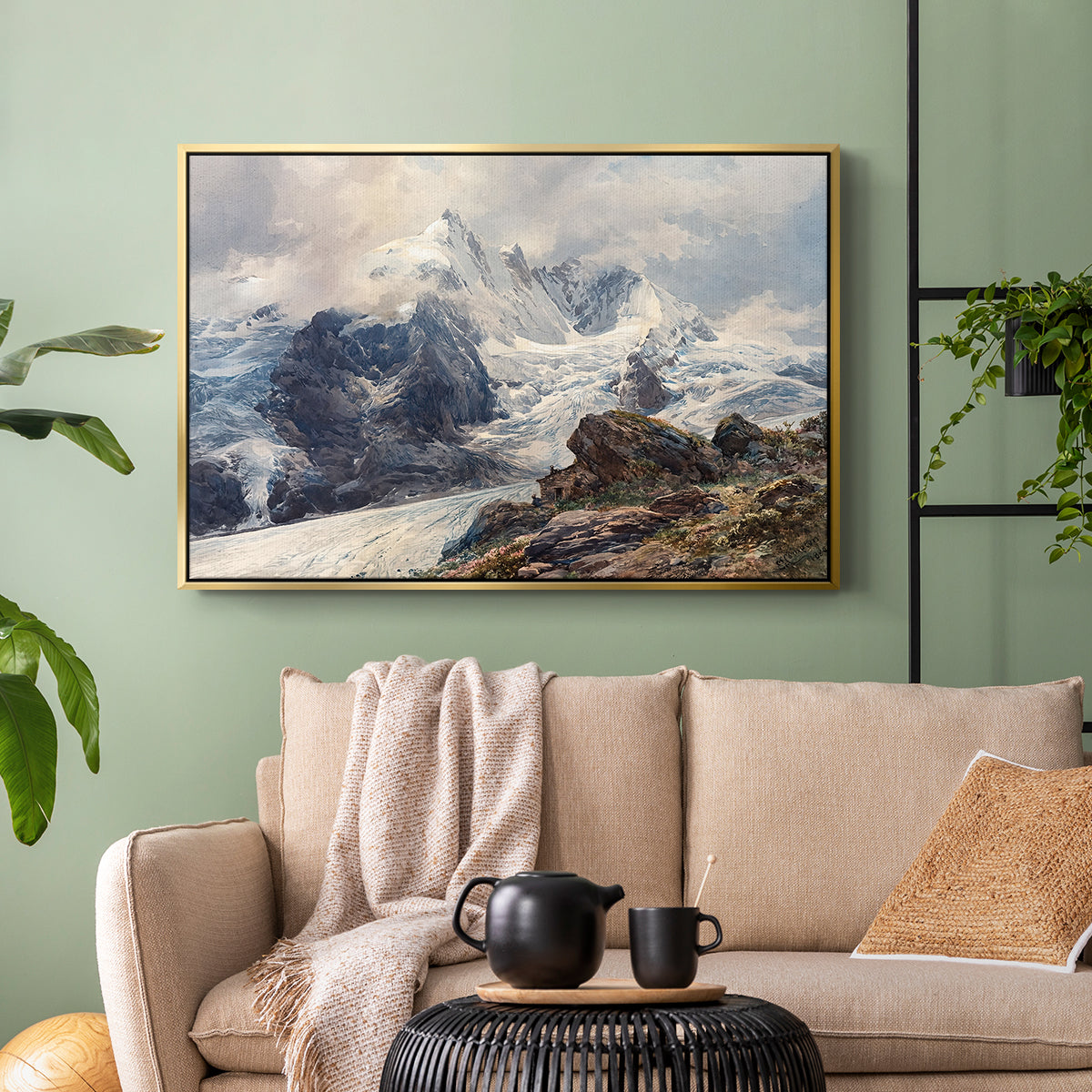 Gold floater framed canvas featuring an alpine peak dominating surrounding terrain, displayed above a sofa in a modern living room.