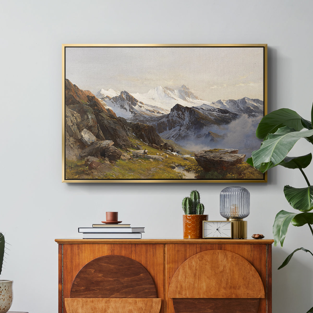 The Großglockner from the Prager Hut, 1890 by Edward Theodore Compton in a gold floater framed canvas featuring a view of Großglockner peak from alpine hut overlooking valley, displayed above a wood console cabinet.