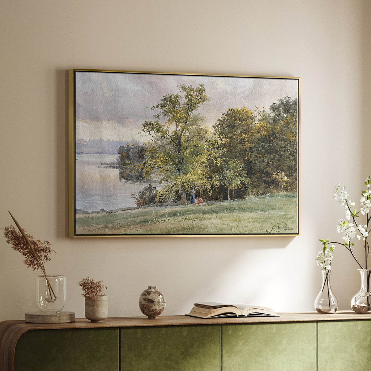 Gold floater framed canvas of Landscape at Lake Starnberg, 1890 by Edward Theodore Compton, featuring a peaceful lake scene with reflections and surrounding greenery above a sideboard in a softly lit hallway.