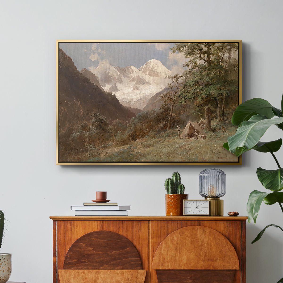 Landscape in the Caucasus, c. 1921 by Edward Theodore Compton in a gold floater framed canvas featuring a mountainous landscape with rugged terrain and distant peaks, displayed above a wood console cabinet.