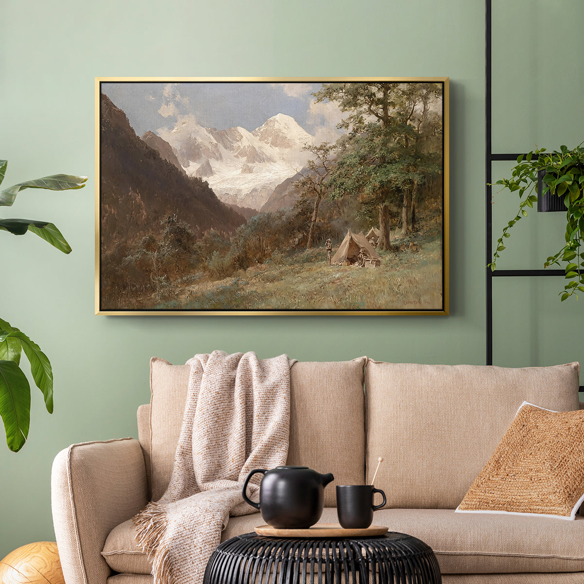 Gold floater framed canvas featuring a realistic depiction of remote mountain environment, displayed above a sofa in a modern living room.