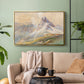 Gold floater framed canvas featuring a realistic mountain view with strong geological forms, displayed above a sofa in a modern living room.