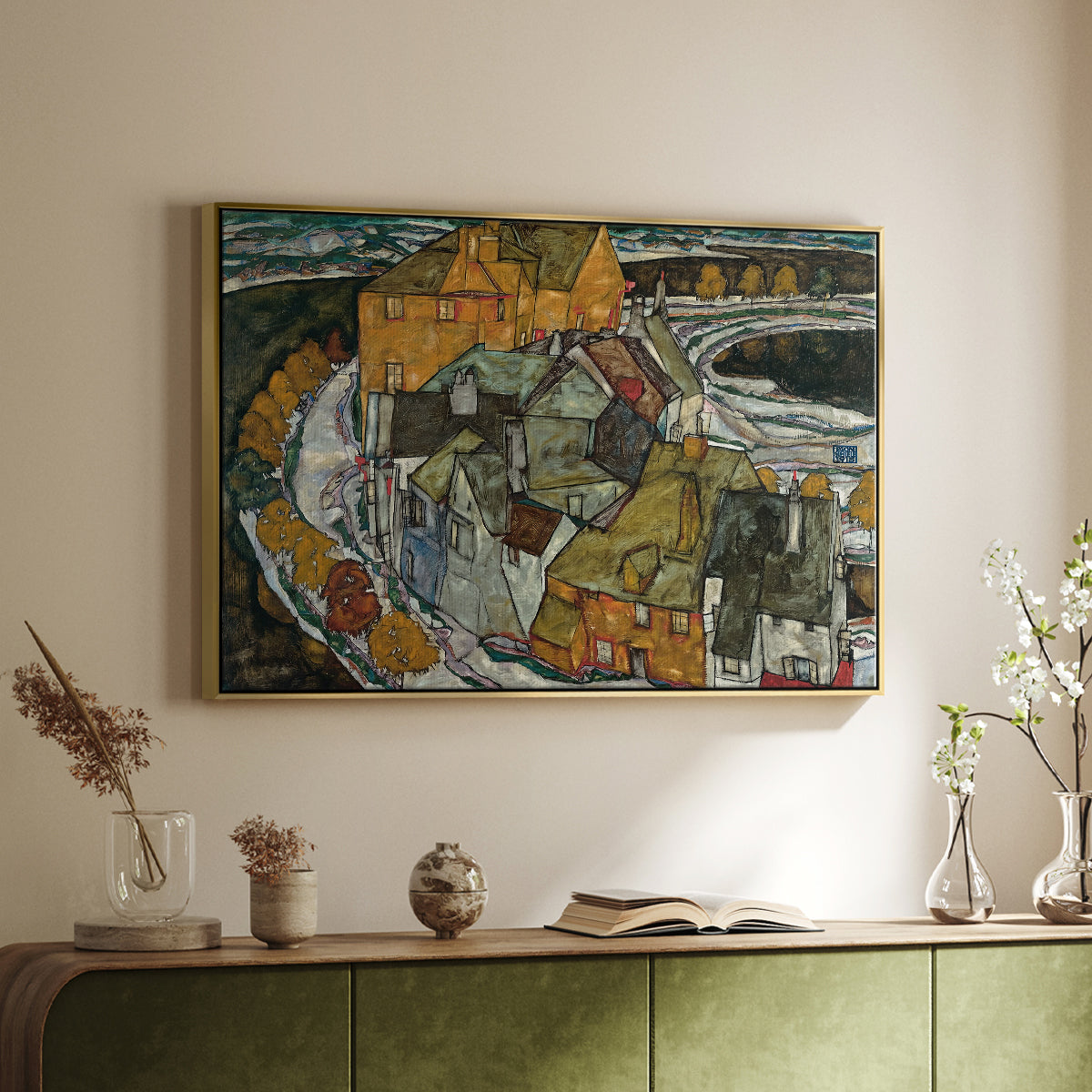 Gold floater framed canvas of Crescent of Houses II (Island Town), 1915 by Egon Schiele, featuring a stylized townscape with clustered buildings and bold outlines above a sideboard in a softly lit hallway.